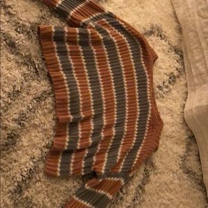 A green and brown striped sweater crop top .